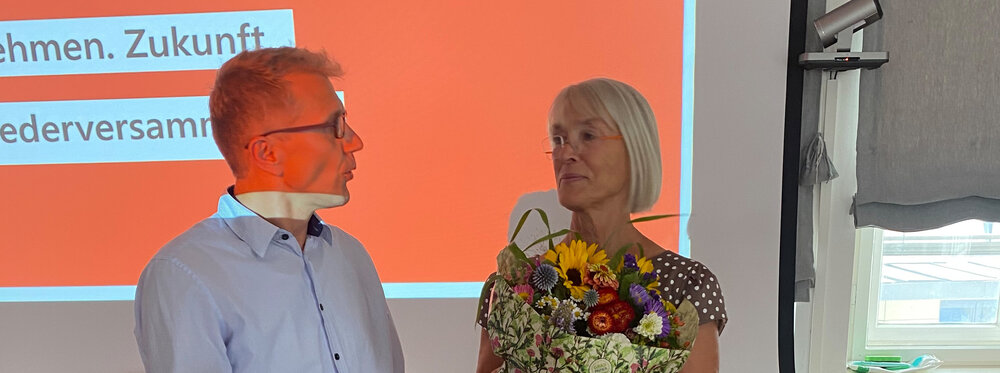 Herr Wissinger überreicht Frau Zeller vom RKW Bayern Blumen.